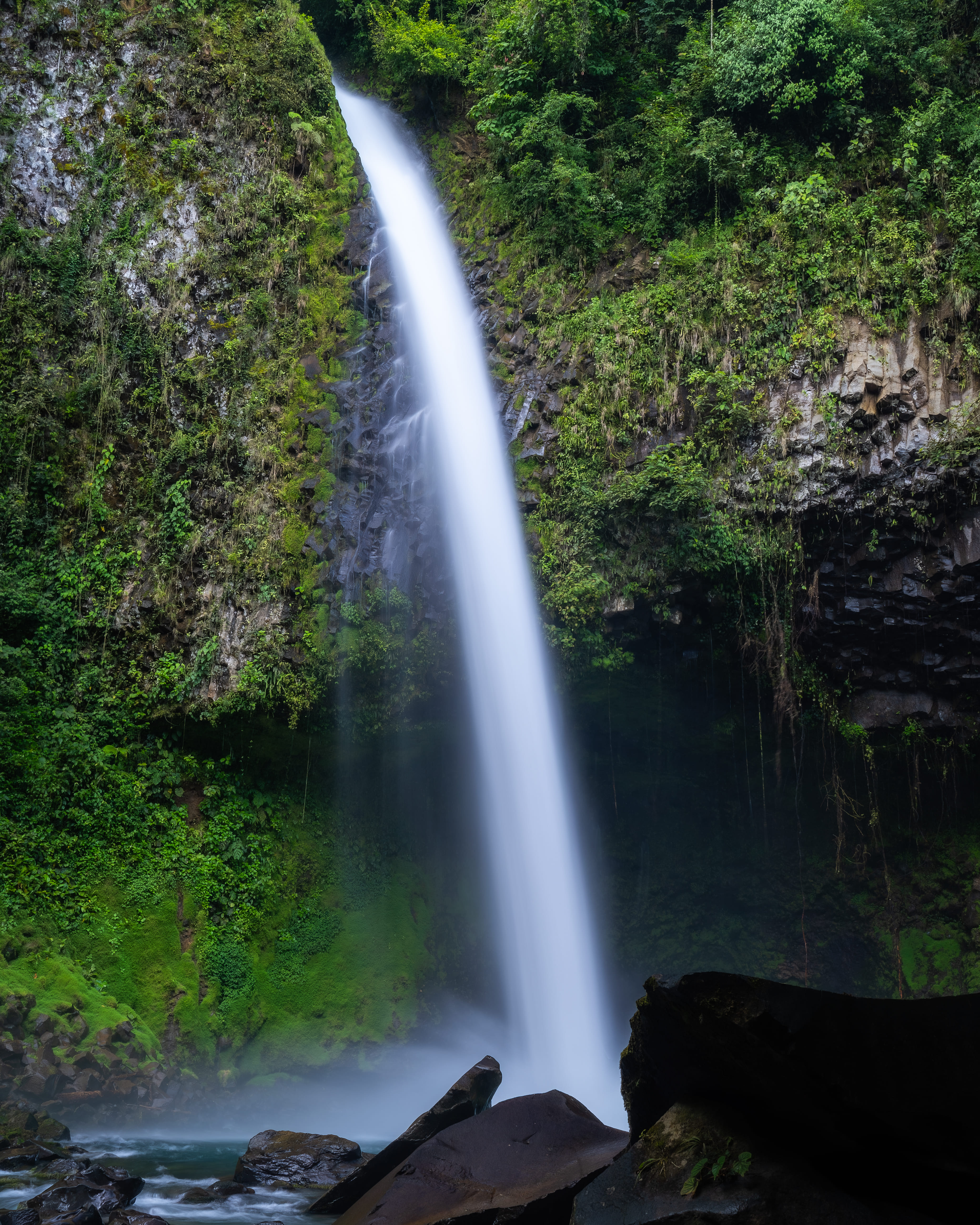 Catarata Río Fortuna de 70 metros cayendo entre paredes de roca volcánica cubiertas de vegetación tropical