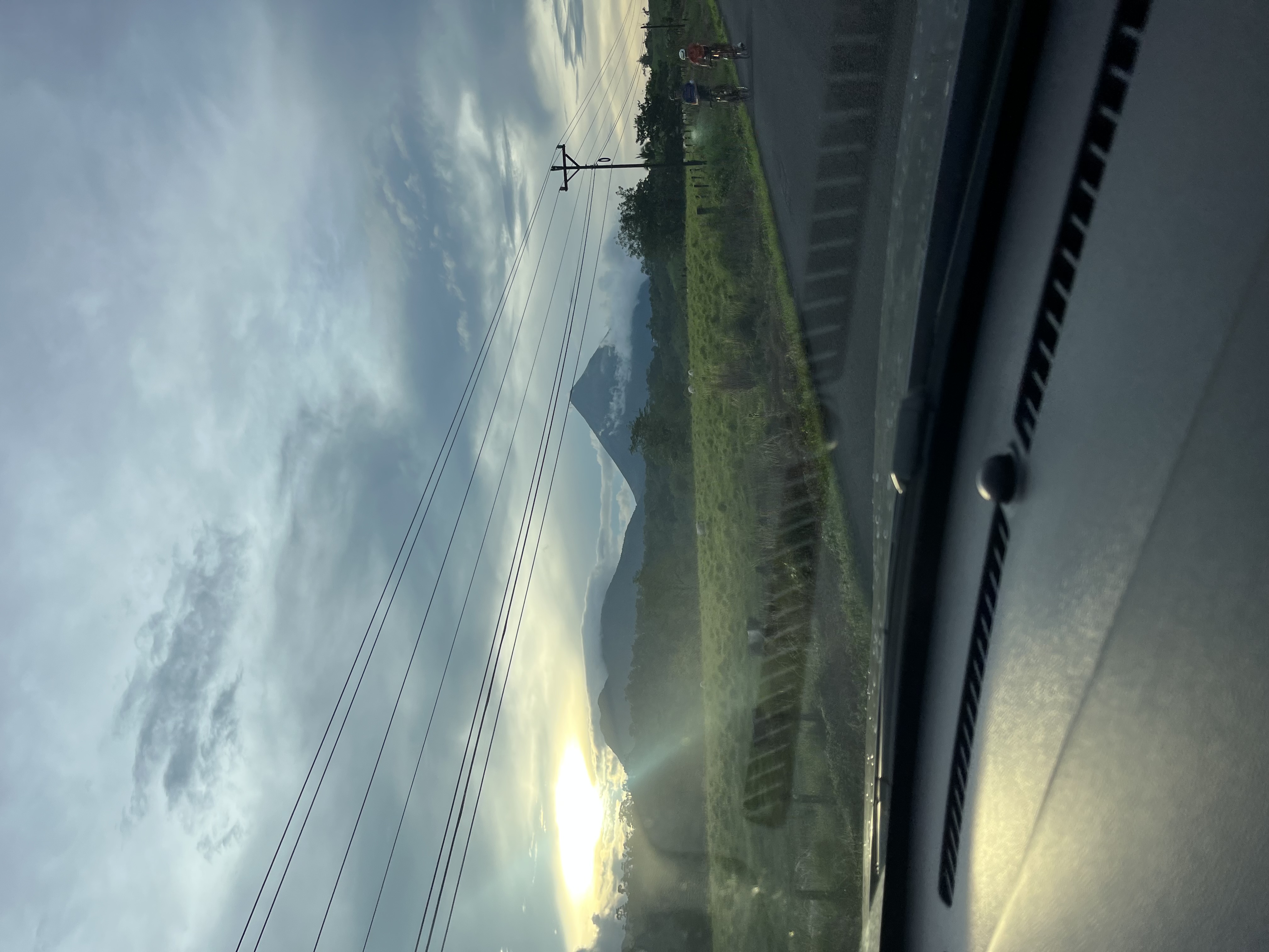 Camino rural mojado bajo cielo nublado en la estación lluviosa